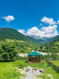 a gazebo with chairs and tables on a hill at Mountain Shadow Cottage in Racha in Ghebi