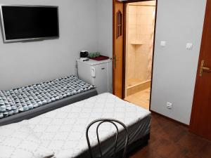 a bedroom with a bed and a tv on the wall at Domek STABOL in Kołobrzeg
