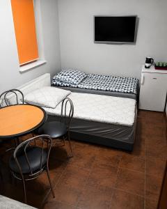 a small room with a bed and a table and chairs at Domek STABOL in Kołobrzeg