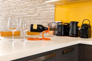 a wine bottle being poured into wine glasses on a counter at Villetta a schiera con vista lago mozzafiato in Lovere