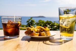 a table with a plate of food and two drinks at Alazne Enea in Bermeo