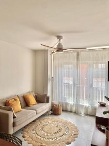 a living room with a couch and a large window at Apartament Natura amb Calma in Olot