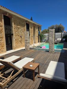 a deck with chairs and a table and a pool at Volakas Beachfront Suites in Rethymno