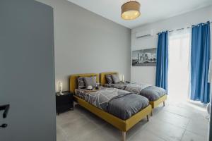 a bedroom with a large bed with blue curtains at St Julians`s Urban Apartments in Is-Swieqi
