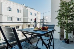 a table with a bottle of wine and fruit on a balcony at St Julians`s Urban Apartments in Is-Swieqi
