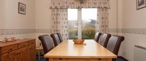 a dining room with a table and chairs and a window at Farmhouse in Roybridge