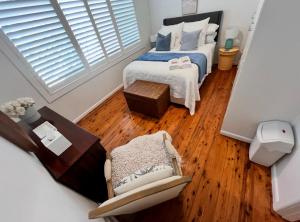 a small bedroom with a bed and a chair at Marley's at Boma in Bomaderry
