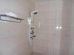 a bathroom with a shower with a shower head at Hotel Residence Flamani in Lomé