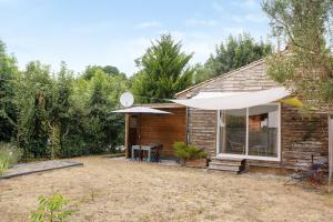 a house with an umbrella and a table and chairs at Chalet Studio Athome in Bouhet