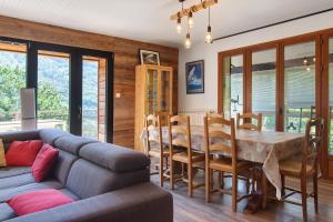 a living room with a couch and a table and chairs at Gite Les Grillons in Belvédère