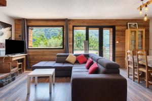 a living room with a couch and a tv at Gite Les Grillons in Belvédère