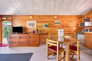 a kitchen with a wooden wall with a table and chairs at Chalet Studio Athome in Bouhet