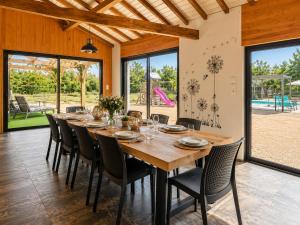 a dining room with a large wooden table and chairs at DOMAINE DE LA PORTE in Agonac