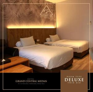 two beds in a hotel room with a poster of the deluge at Grand Central Medan in Medan +20 photos
