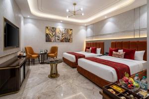 a hotel room with two beds and a television at Hotel Skynex - Near Delhi Aerocity in New Delhi +13 photos