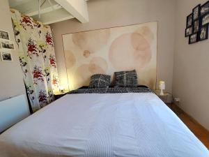 a bedroom with a large white bed with two pillows at Reve azur plage en duplex coeur de village in Le Pradet