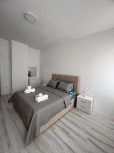 a bedroom with a bed with two towels on it at Best House Albania in Kamëz