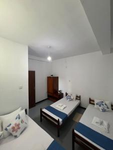a room with two beds and a cabinet in it at Kandy Green Nature Villa in Kandy