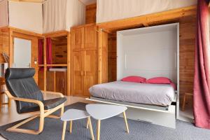 a bedroom with a bed and a chair and a table at Chalet Studio Athome in Bouhet