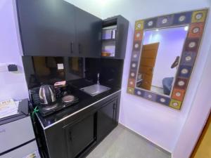 a small kitchen with a sink and a mirror at Studio moderne in Saly Portudal