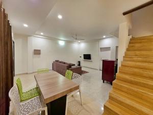 a living room with a table and a couch at II EMPYREAN STAYS II WHITE PANTHER VILLA II 3BHK II AC II PRIVATE POOL ll in Lonavala