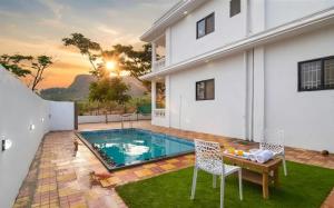 a swimming pool in the backyard of a house at II EMPYREAN STAYS II WHITE PANTHER VILLA II 3BHK II AC II PRIVATE POOL ll in Lonavala