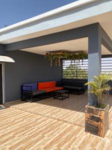a covered patio with a couch and a table at Studio moderne in Saly Portudal