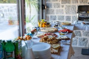 a table with many plates of food on it at Agape Rose in Tivat