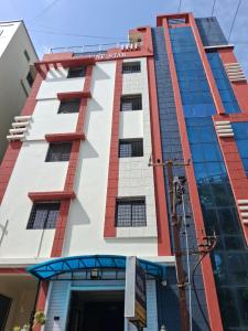 a tall building with red and white at Hotel 9 square in Shamshabad