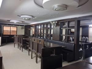 a dining room with tables and chairs in a restaurant at Hotel 9 square in Shamshabad