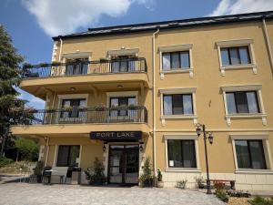 a yellow building with a port lease sign on it at Port Lake Hotel in Beloslav