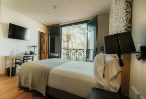 a hotel room with a bed and a window at Hotel Estepona Plaza in Estepona