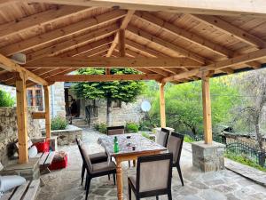 a wooden pavilion with a table and chairs on a patio at Vila Korcari Dardhe in Dardhë