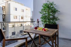 a table with a plate of fruit on a balcony at St Julians`s Charm Apartments in Is-Swieqi