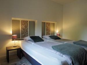 two beds in a bedroom with two lamps on a table at Hoeve op de Meer in Maastricht