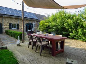 a wooden table and chairs on a wooden deck at Hoeve op de Meer in Maastricht