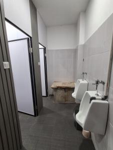 a bathroom with two sinks and two urinals and a window at Nglinteg Hostel in Yogyakarta