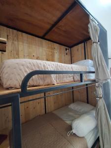 two bunk beds in a wooden walled room at Nglinteg Hostel in Yogyakarta