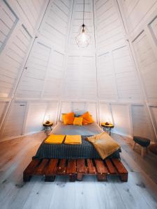 a bedroom with a large bed in a white room at Glamping The Teepee in Mombeltrán