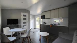 a kitchen with a table and chairs and a kitchen with a counter at Guliwer in Niechorze