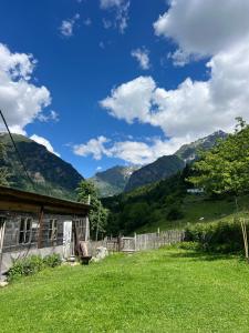 a house in a field with mountains in the background at Otisha Guesthouse in Tsaldashi