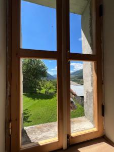 an open window with a view of a green field at Otisha Guesthouse in Tsaldashi +4 photos