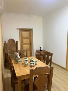 a dining room table with chairs and a table with cups at Otisha Guesthouse in Tsaldashi