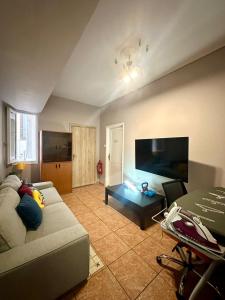 a living room with a couch and a flat screen tv at Alpha - City Center Rooms Athens in Athens