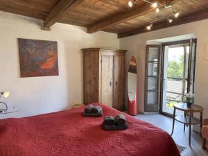 a bedroom with a red bed with shoes on it at Al Torchio by Fewotessin in Riazzino