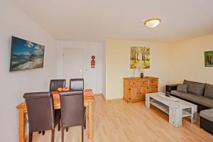 a living room with a couch and a table at Waldsiedlung Waldhaus App 4.1 in Korswandt
