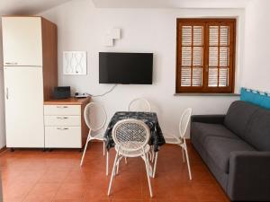 a living room with a table and chairs and a couch at Perla Marina Tropea in Parghelia