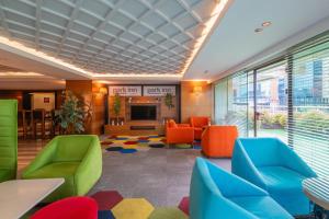 a lobby with colorful chairs and a television at Park Inn by Radisson Istanbul Asia Kavacik in Istanbul