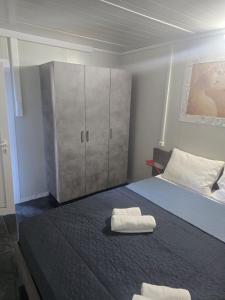 a bedroom with a bed with two towels on it at Krikonis Apartments Leptokarya in Leptokarya