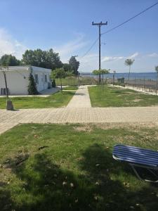 a blue bench sitting in the grass next to a sidewalk at Krikonis Apartments Leptokarya in Leptokarya